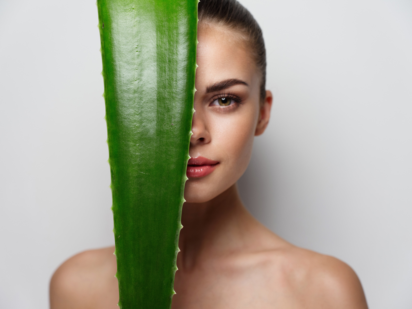Portrait of  Woman with Green Aloe Leaf Bare Shoulders Clear Skin Model